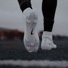 a person's feet in white and black running shoes