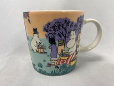 a coffee cup with moomi characters painted on the outside and inside, sitting on a white surface