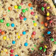 a cookie with chocolate chips, m & m and m's on top in a pan