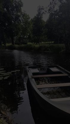 there is a boat that is sitting on the side of the river in the dark