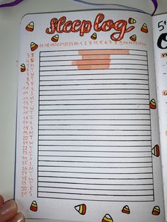 a hand holding an open planner book with candy on the pages and writing in it