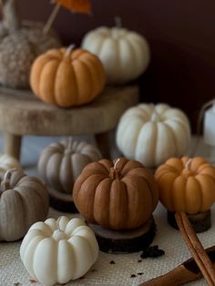 small pumpkins and cinnamon sticks on a table with other decorative items in the background