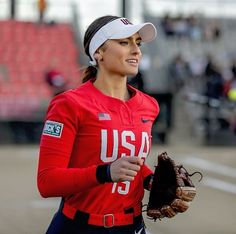 a female baseball player wearing a red uniform and holding a catchers mitt