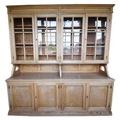 an old wooden hutch with glass doors and drawers on top, isolated against a white background