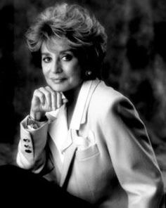 black and white photograph of woman sitting on the ground with her hand under her chin