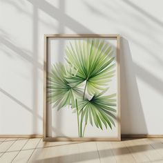 an image of a palm leaf in a frame on the floor next to a wall