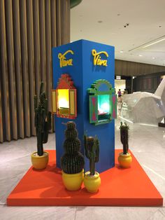 cactus plants are displayed in front of a vending machine at an indoor shopping mall