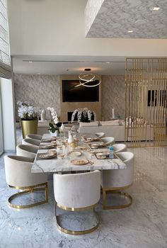 an elegant dining room with marble tables and white chairs, gold trim around the table