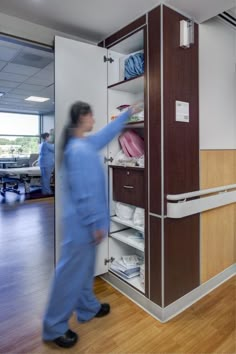 a woman in scrubs is looking at the closet