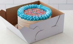 a cake in a box with sprinkles and blue icing on it