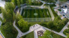 an aerial view of a soccer field surrounded by trees