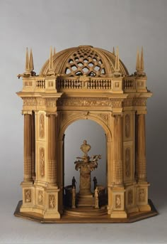 an intricately carved wooden structure with a statue in the center and statues on either side