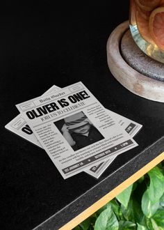 a newspaper sitting on top of a table next to a potted plant