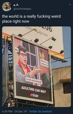 an advertisement on the side of a building with a man pointing to something in front of it