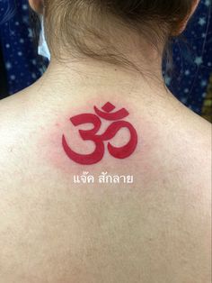 the back of a woman's neck with an om shan tattoo