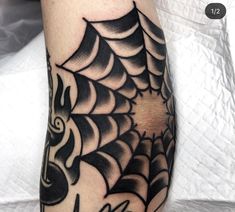 a black and white spider web tattoo on the leg