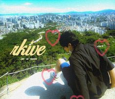 a man sitting on top of a hill next to a city