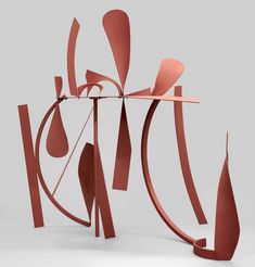 an abstract sculpture made out of red paper and metal pipes, on a white background