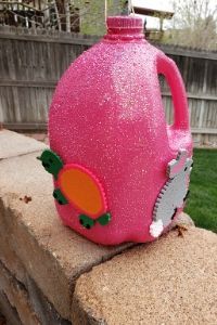 a pink jug sitting on top of a brick wall