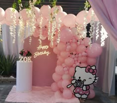 a hello kitty birthday party with balloons and flowers