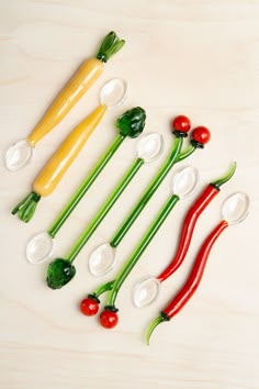 six peppers and two pepper shakers on a white surface with green, yellow, red, and orange peppers