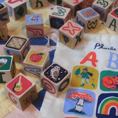 children's wooden alphabet blocks and numbers on a tablecloth with colorful fabric around them