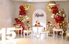 a room filled with tables and chairs covered in red, gold and white balloons next to a wall