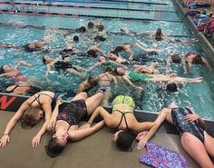 several people are swimming in the pool together