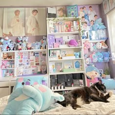 a cat laying on top of a bed next to a book shelf