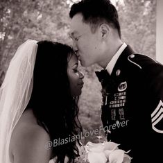 a man in uniform kissing a woman on the cheek