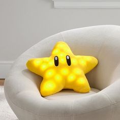 a yellow star pillow sitting on top of a white chair