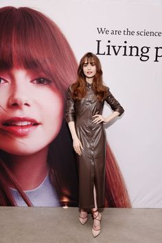 a woman standing in front of a poster