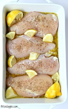 chicken with lemons and seasoning in a casserole dish