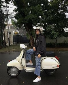 a man sitting on top of a white scooter