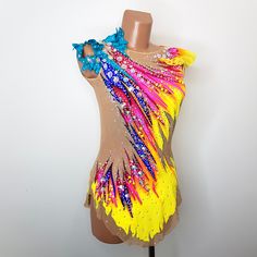 a female mannequin wearing a yellow, blue and pink dress with sequins on it