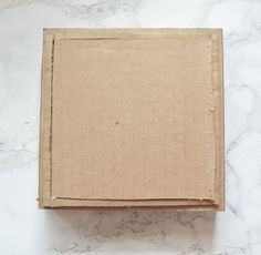 an open cardboard box sitting on top of a marble counter next to a white wall