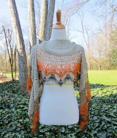 a white mannequin with an orange and gray crochet top on it