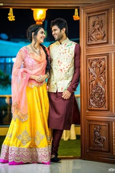 a man and woman standing in front of an open door