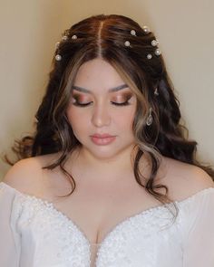 a woman in a wedding dress with pearls on her head