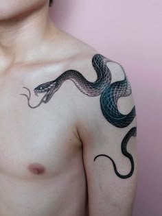 a man's chest with a snake tattoo on his left shoulder and the other arm