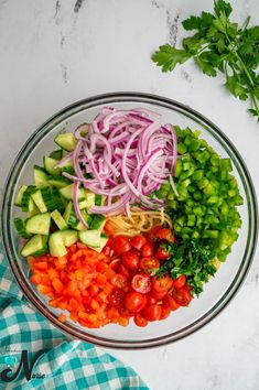 the ingredients for this salad are neatly arranged in a bowl, including tomatoes, cucumbers and onions