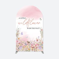 a pink and white sign with flowers on it that says, little wildflower is on the way