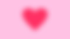 a red heart on a pink background with some blurry light coming from the top