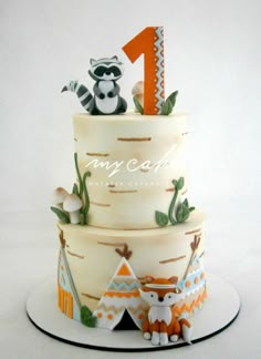 a three tiered cake decorated with animals and trees