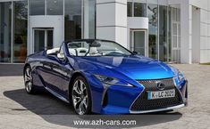 a blue sports car parked in front of a building