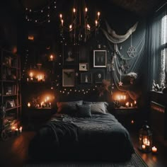 a dark bedroom with candles and pictures on the wall