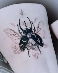 a tattoo on the back of a woman's thigh with two bugs and stars