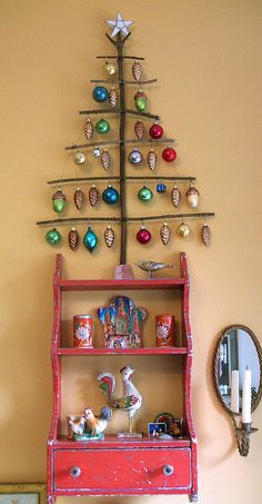 a red shelf with ornaments and a christmas tree on top