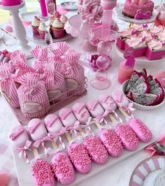 a table topped with lots of pink desserts