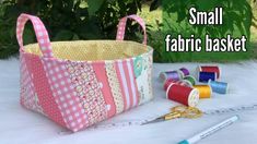 small fabric basket with thread spools and scissors